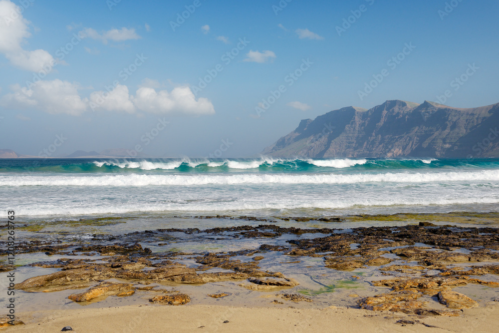 The beach Playa at La Caleta de Famara. Lanzarote, Canary Islands. Looking to cliffs of Risco de Famara