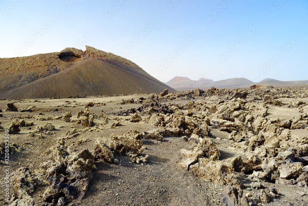 Crossing cinder field to volcanic cone of Caldera de los Cuervos. Timanfaya National Park, Lanzarote, Canary Islands, Spain