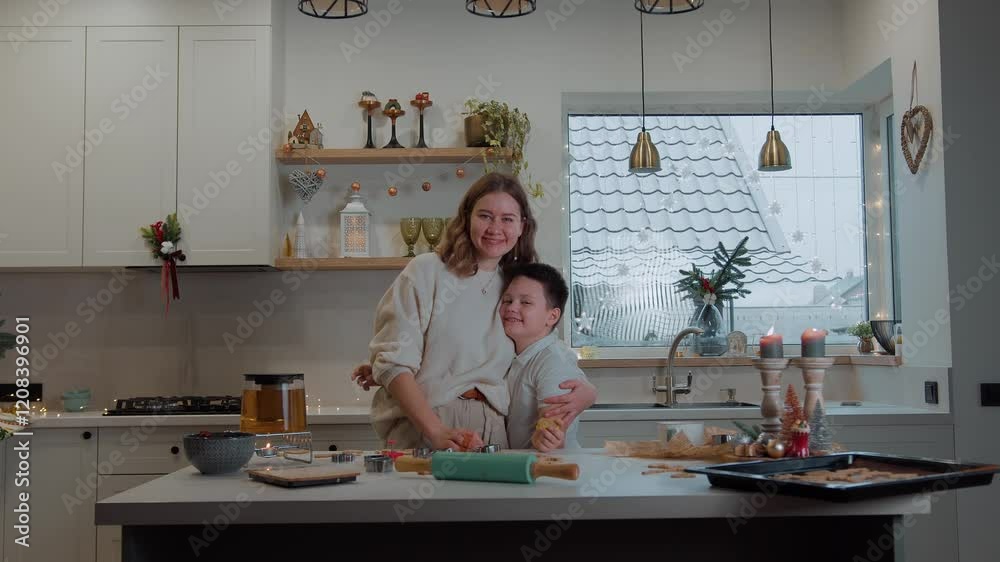 Portrait of happy mother and son hugging while baking Christmas cookies. Relationships between children and parents are based on love, respect and common interests Portrait of happy mother and son hugging while baking Christmas cookies. Relationships between children and parents are based on love, respect and common interests