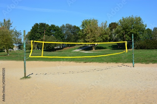 Outdoors empty beach volleyball arena with poles and net in park in sunny summer day. photo