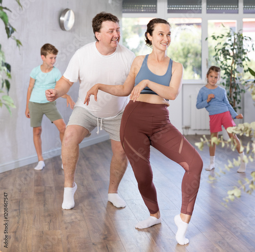 Photography .Cheerful joyful family performs a workout for amateurs. Parents with a young da