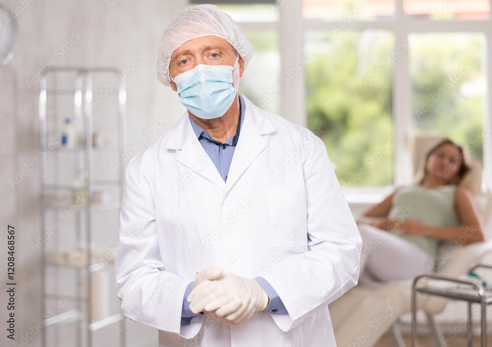 Advertising banner of cosmetology office clinic. Senior male doctor after appointment. Private outpatient practice. Individual approach to treatment. Blurry female patient in background Advertising banner of cosmetology office clinic. Senior male doctor after appointment. Private outpatient practice. Individual approach to treatment. Blurry female patient in background