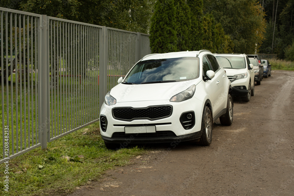 Cars in the parking lot in summer. Parking near the house. Personal transport in the city. Cars in the parking lot in summer. Parking near the house. Personal transport in the city.