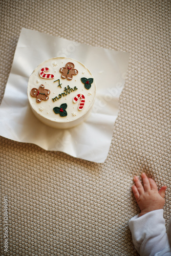 a child dressed in Christmas clothes like a little gnome pokes a Christmas cake with his finger, wants to know what the consistency is, experiments, learns about the world photo