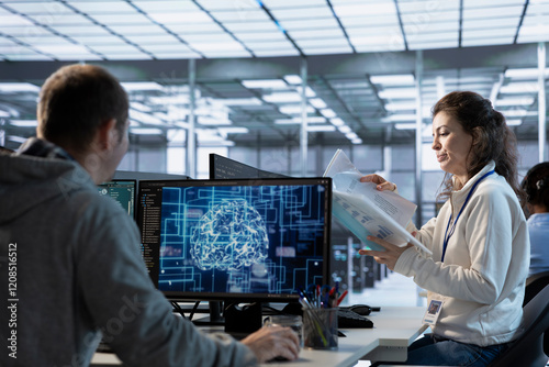 Manager looking over paperwork in machine learning server farm to ensure compliance with industry standards and regulatory requirements. Supervisor overseeing data center security protocols