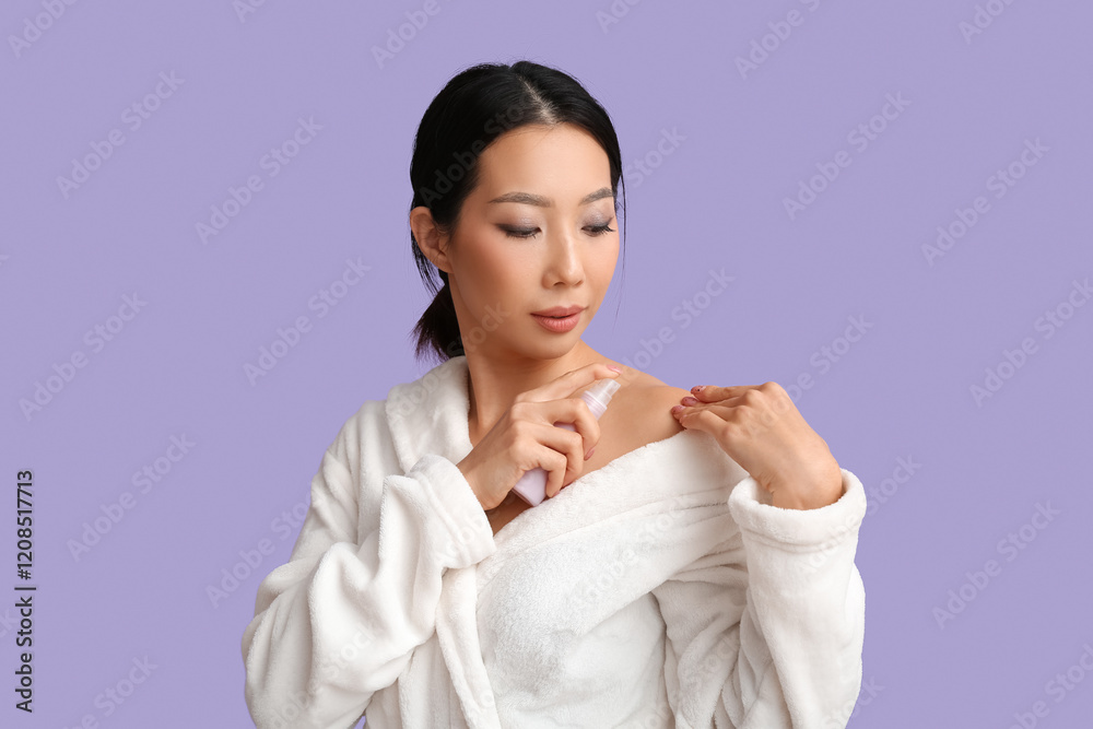 Young Asian woman in bathrobe applying serum on lilac background Young Asian woman in bathrobe applying serum on lilac background