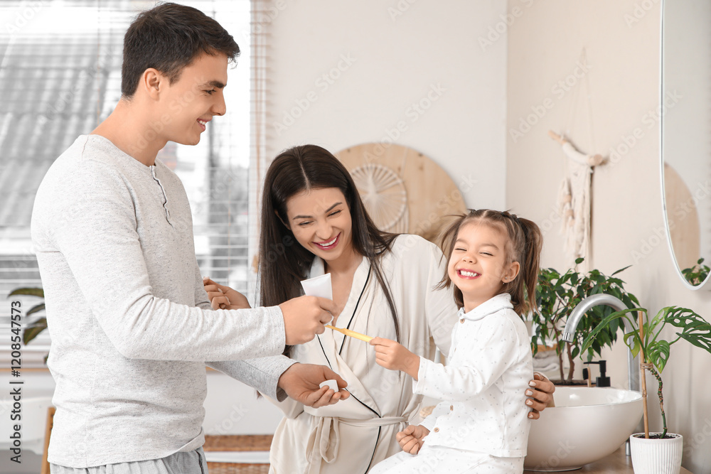 Happy family with cute little daughter and toothbrushes in bathroom Happy family with cute little daughter and toothbrushes in bathroom