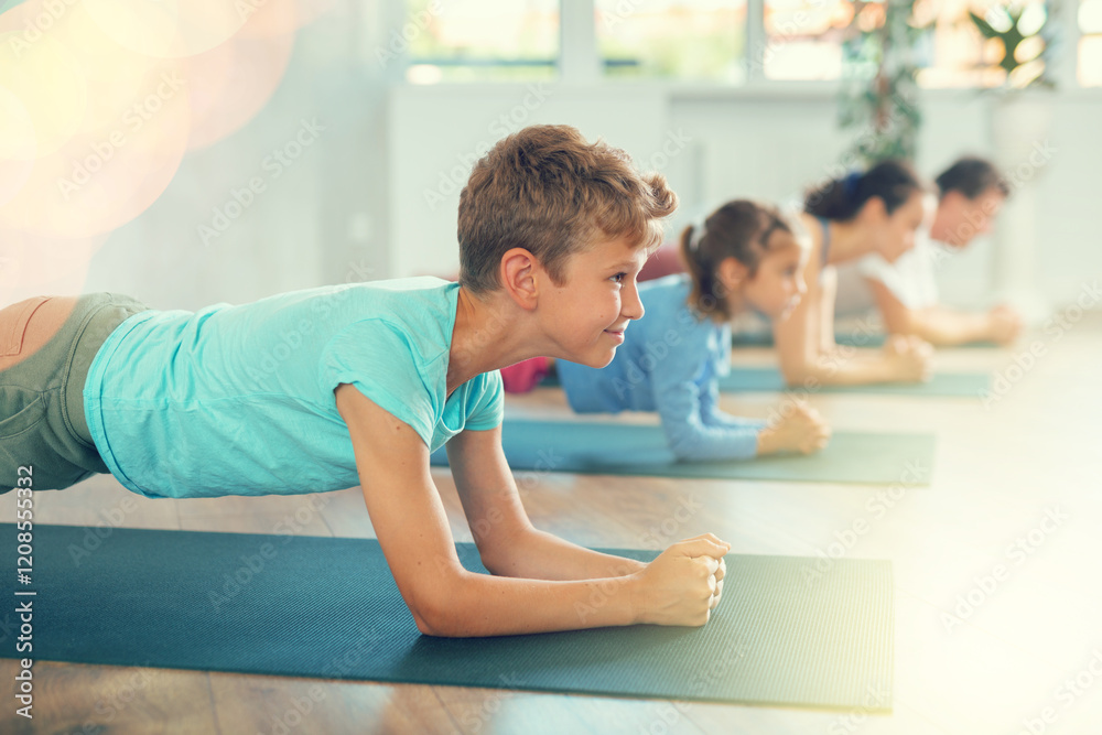 Little boy with parents and brother doing yoga in fitness class Little boy with parents and brother doing yoga in fitness class