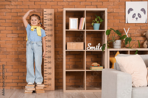 Little girl on books measur...