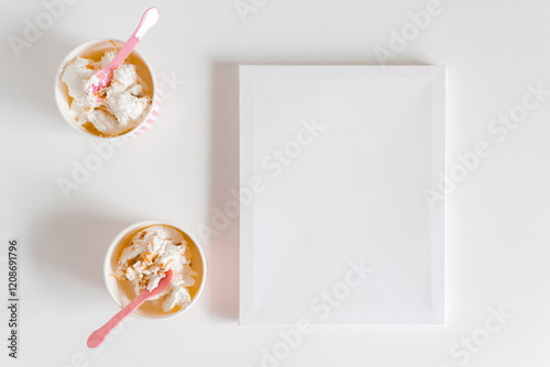 Ice cream boxe and cute pink spoon with empty canva. White background. Mockup for design, template with copy space, flat lay
