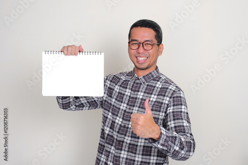 A man smiling happy and give thumb up while holding empty white paper photo