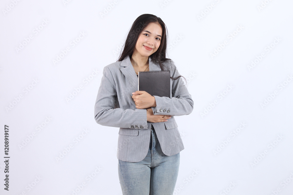 Beautiful womanwearing a gray blazer and jeans is holding a book. Business asian woman Beautiful womanwearing a gray blazer and jeans is holding a book. Business asian woman