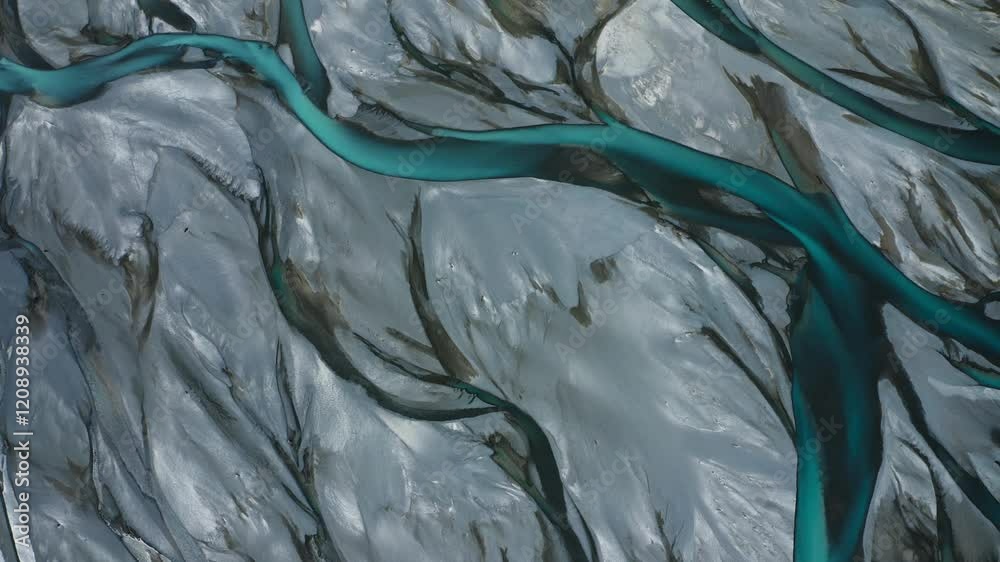 Top down drone shot of Blue Glacial Braided River veins and streams weave and flow through grey landscape, New Zealand