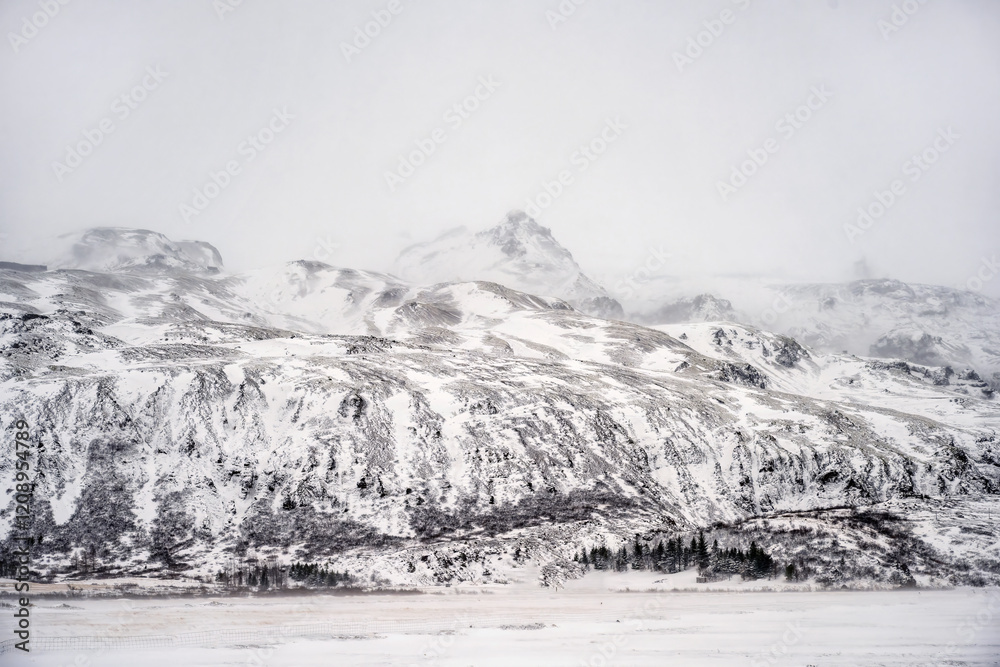 Obraz premium Landscape view of snow covered mountains in Iceland. Nature, travel, winter background, or wallpaper