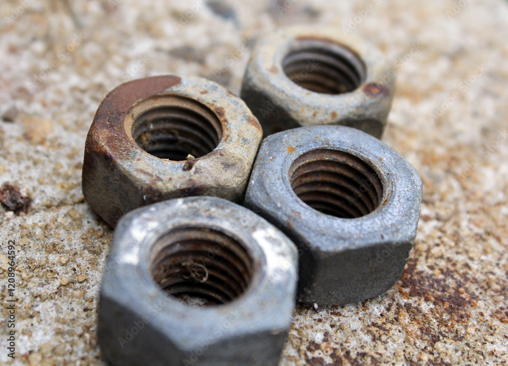 Close-up of rusty metal nuts on a cement background Close-up of rusty metal nuts on a cement background