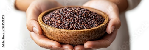 Hands holding a wooden bowl of dark rice grains