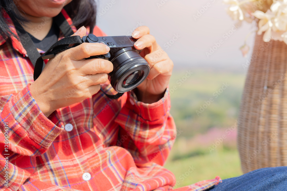 Naklejka premium Hipster tourist girl hold in hands take photography click on modern photo camera.