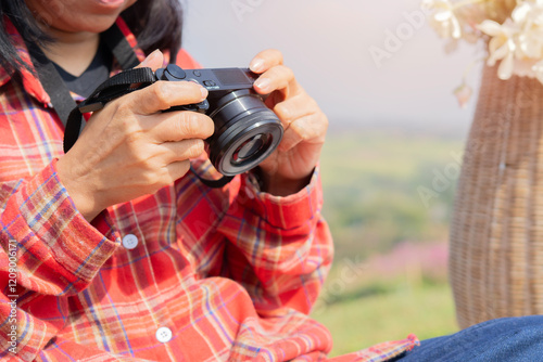 Hipster tourist girl hold in hands take photography click on modern photo camera. photo