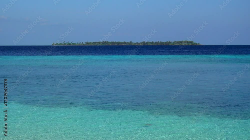 View of uninhabited tropical island from coral lagoon. View of uninhabited tropical island from coral lagoon.