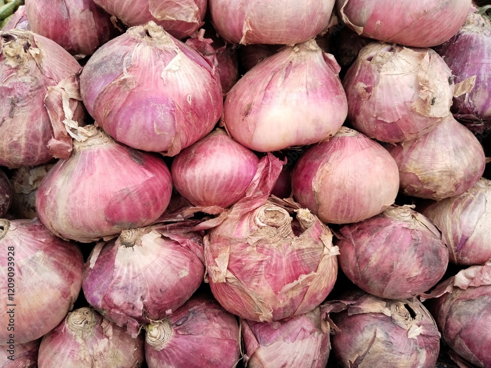 Pile of fresh organic red onions arranged closely, showcasing their natural texture and vibrant color, ideal for agriculture, cooking, and market concepts. Pile of fresh organic red onions arranged closely, showcasing their natural texture and vibrant color, ideal for agriculture, cooking, and market concepts.