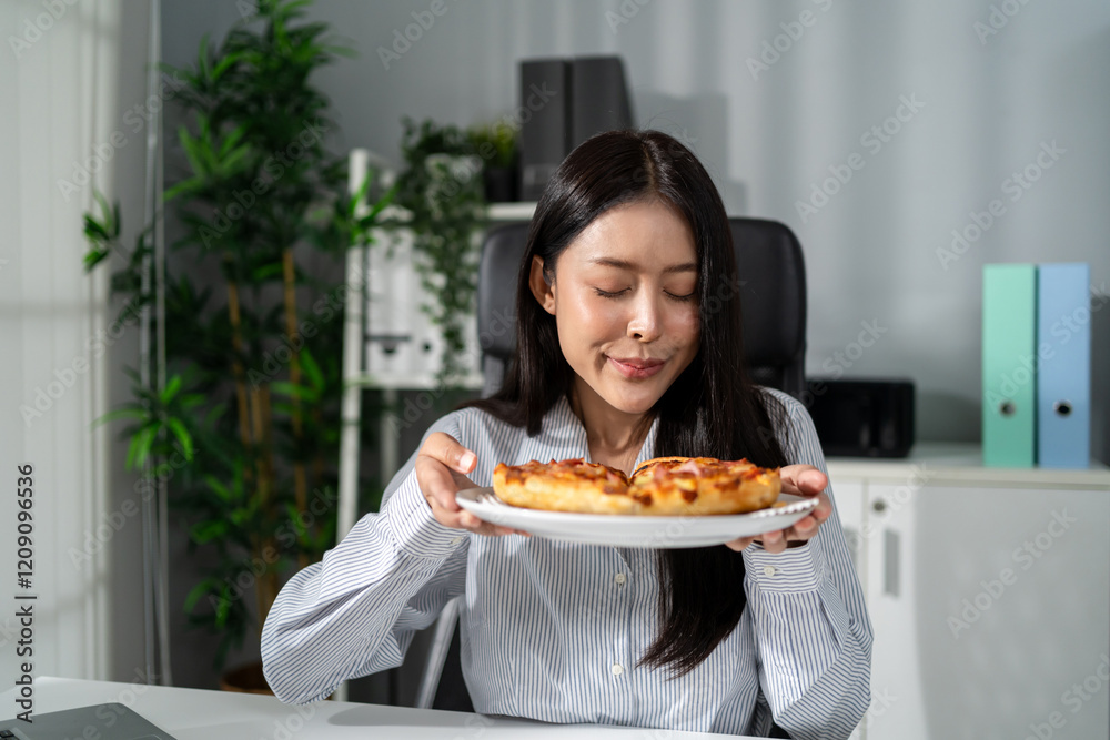 Asian young businesswoman eating homemade pizza while working in office. Asian young businesswoman eating homemade pizza while working in office.
