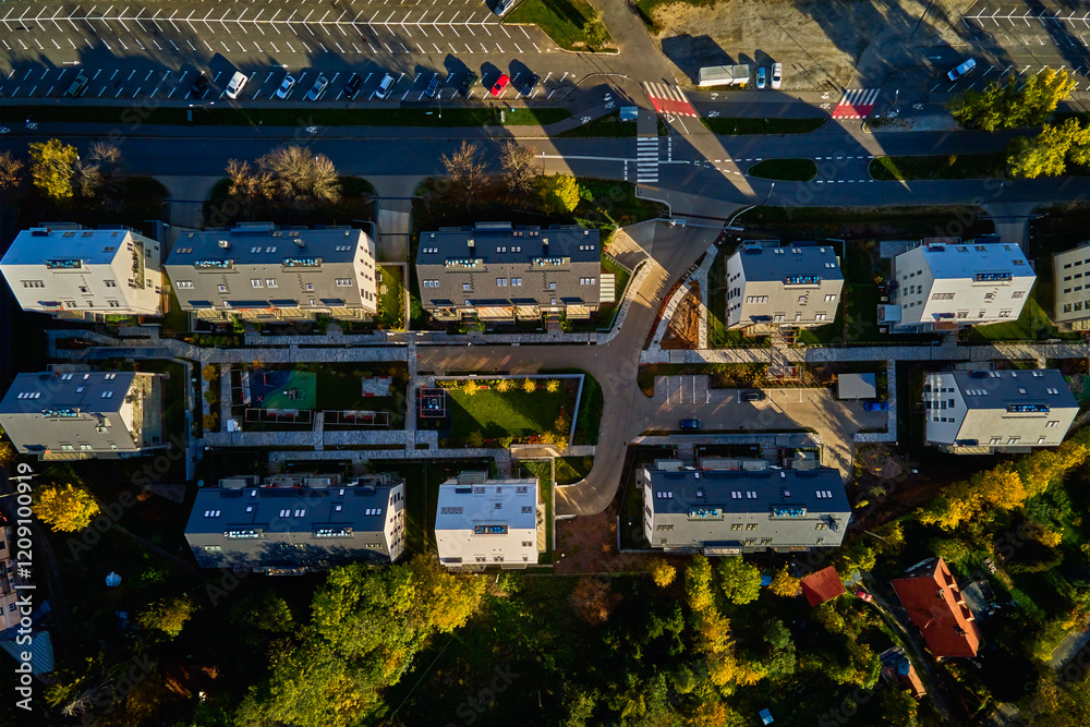 Obraz premium Top view of modern residential neighborhood with contemporary apartment buildings, green spaces, parking areas and well-maintained pathways on sunny day