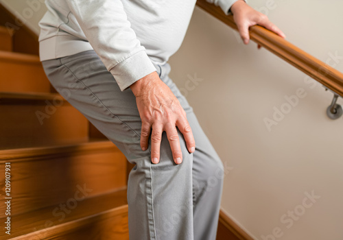 階段を降りるときに膝が痛む高齢者の男性