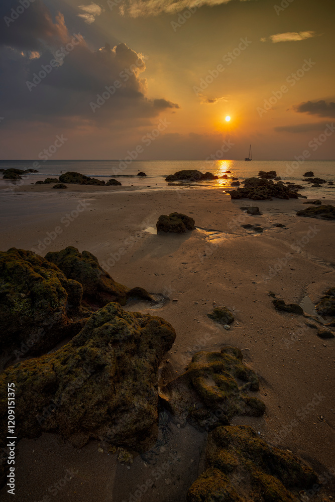 Beautiful landscape of rocky and empty Long Beach (Phra Ae Beach), sea, sun and cloudy sky during sunset in Koh Lanta, Thailand. Beautiful landscape of rocky and empty Long Beach (Phra Ae Beach), sea, sun and cloudy sky during sunset in Koh Lanta, Thailand.