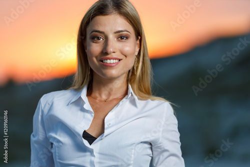 Φωτογραφία Portrait of young smiling woman standing outdoors at sunset