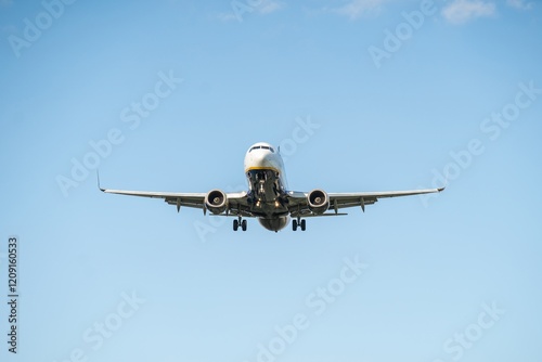 Obraz na płótnie Commercial airplane approaches landing during clear sky with minimal clouds in the background w salonie