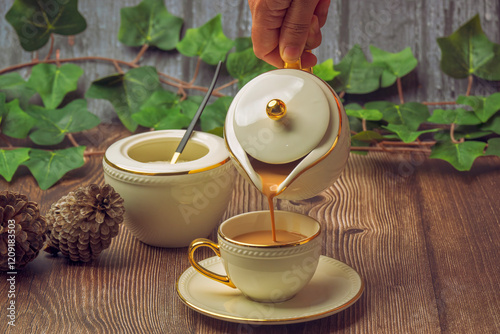 Obraz na płótnie Indian masala chai tea. Masala chai spiced tea with milk and spices or karak chai or cutting chai. Tea being poured into ceramic glasses from a tea pot and spices on isolated background. w salonie