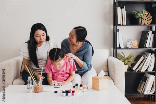 Family enjoys creative painting activity together in a cozy living room space