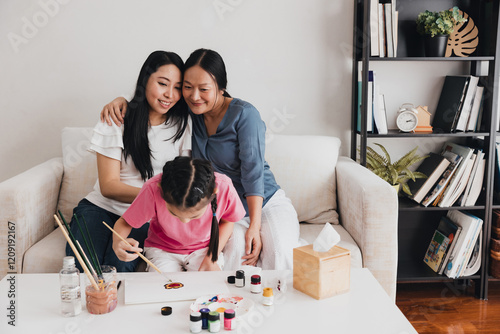 Celebrating family moments with an LGBTQ couple and their adopted child engaged in creative activities at home