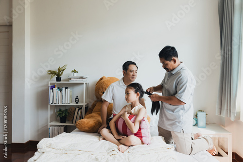 Couple bonds with their daughter while getting her hair styled in a cozy bedroom