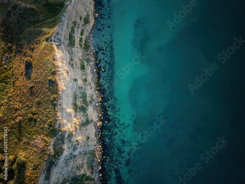 Drone aerial top view of a cliff landscape with sea blue water