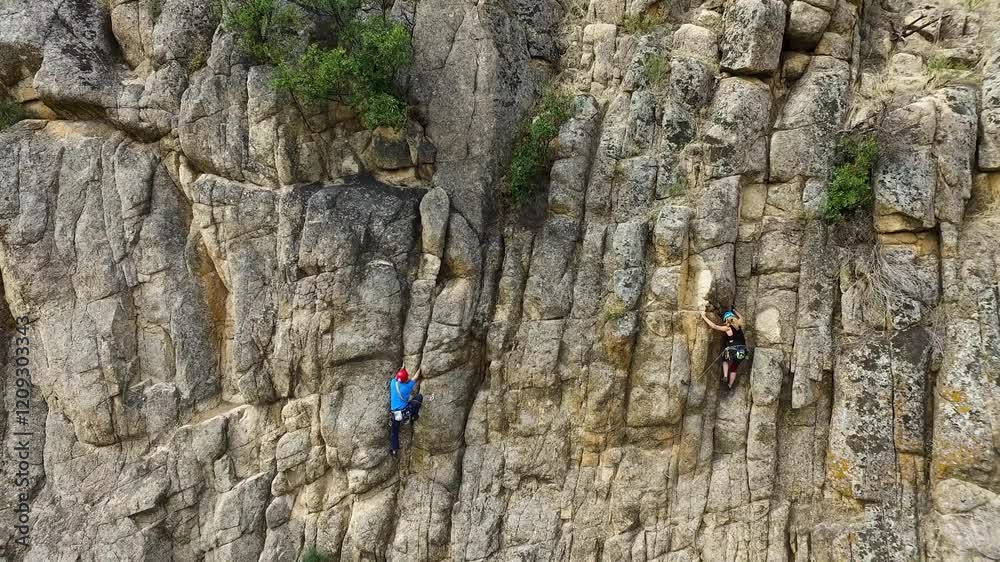 Imagen aérea de un hombre y una mujer escalando por una pared de roca
