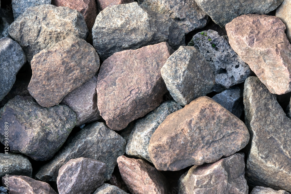 A pile of rough, natural rocks in various earthy tones, showing texture and irregular shapes, suitable for construction or landscaping themes. A pile of rough, natural rocks in various earthy tones, showing texture and irregular shapes, suitable for construction or landscaping themes.
