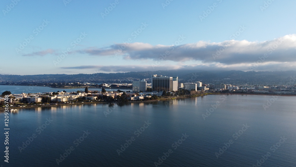 The Emeryville Marina spreads out in this aerial photo, with docks stretching into the calm waters, reflecting the vibrant hues of the setting sun over the Bay Area's tranquil coastal landscape. The Emeryville Marina spreads out in this aerial photo, with docks stretching into the calm waters, reflecting the vibrant hues of the setting sun over the Bay Area's tranquil coastal landscape.