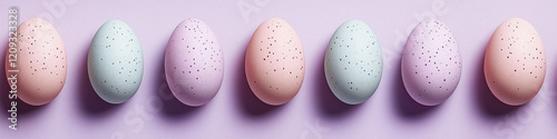 Row of pastel easter eggs creating a repeating pattern on purple background photo