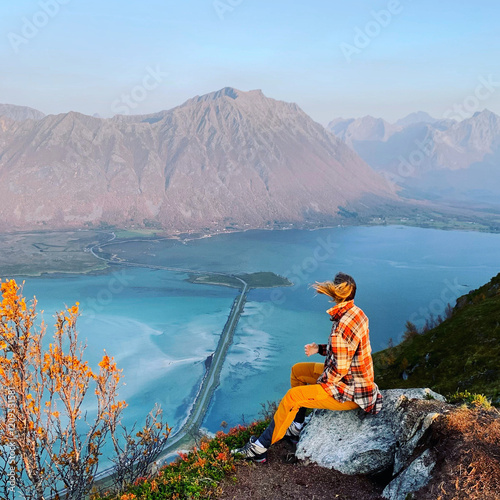 person sitting on the edge of the mountain