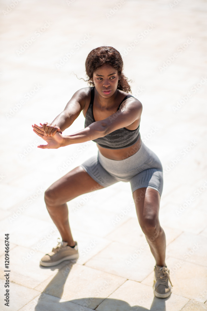 Female athlete works through a dynamic squat exercise Female athlete works through a dynamic squat exercise