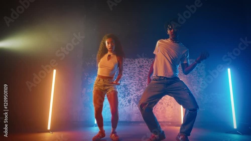 Full-length portrait of couple of black dancers performing dancehall on stage. African American man and woman enjoying rhythm of ethnic music and dancing, modern choreographic sequences and music
