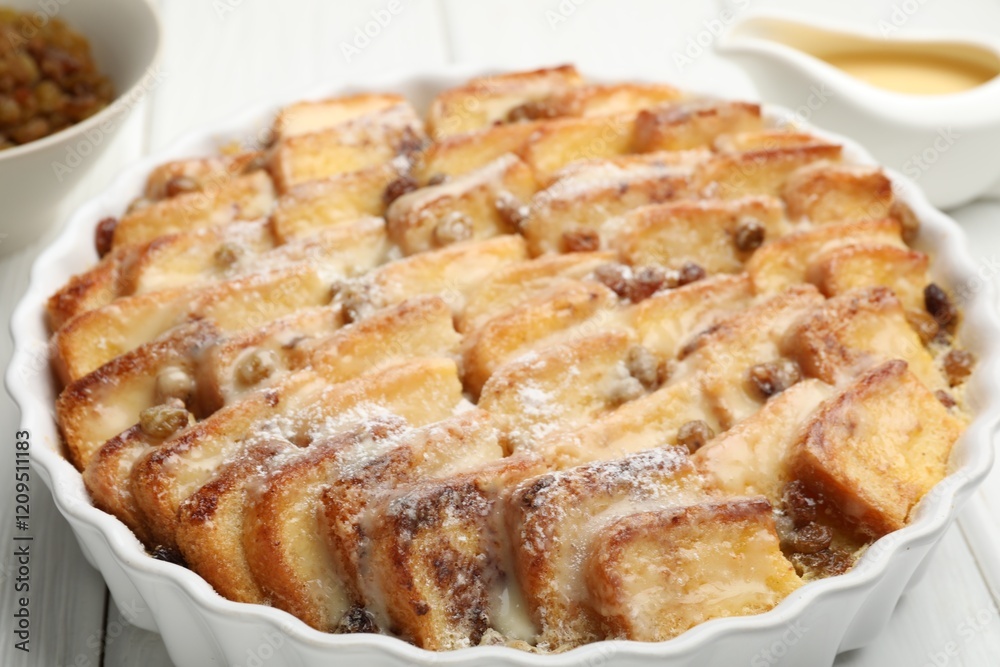 Delicious bread pudding with raisins and powdered sugar on white wooden table, closeup Delicious bread pudding with raisins and powdered sugar on white wooden table, closeup