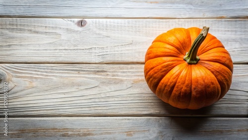 Autumn Harvest: Top View of Single Orange Pumpkin on White Wooden Table photo