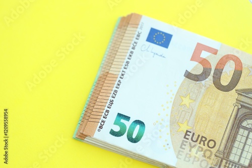 Big amount of one hundred and fifty euro money bills on yellow background photo