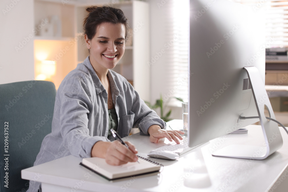 Happy woman working with computer at desk indoors. Home office Happy woman working with computer at desk indoors. Home office