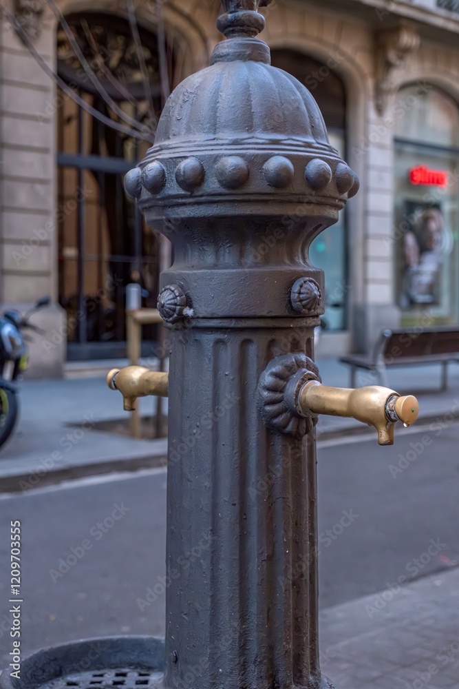 Historic Cast Iron Street Fountain with Ornate Details. Traditional Water Source in Barcelona's Urban Landscape (Barcelona, Catalonia)