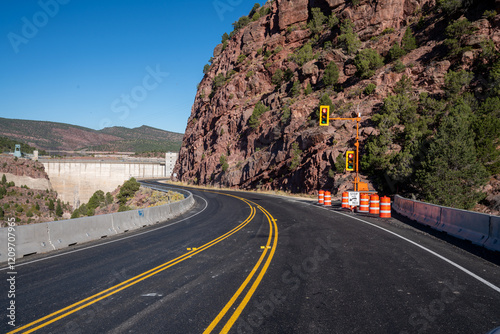 Single-lane construction temporary stoplight controls traffic at a dam while being repaired in the southwest desert.