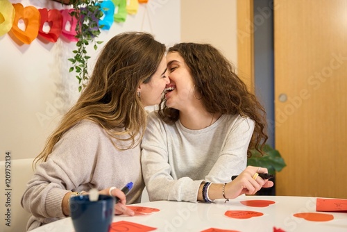 Lesbian couple kissing while preparing valentine's day decorations photo