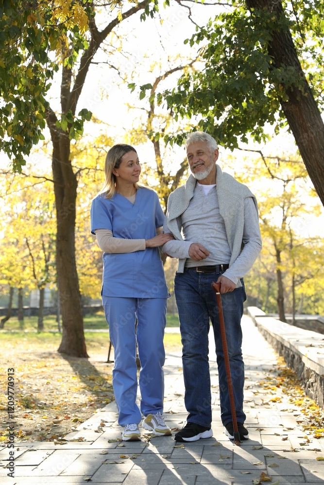 Caregiver assisting senior man in park. Home health care service Caregiver assisting senior man in park. Home health care service